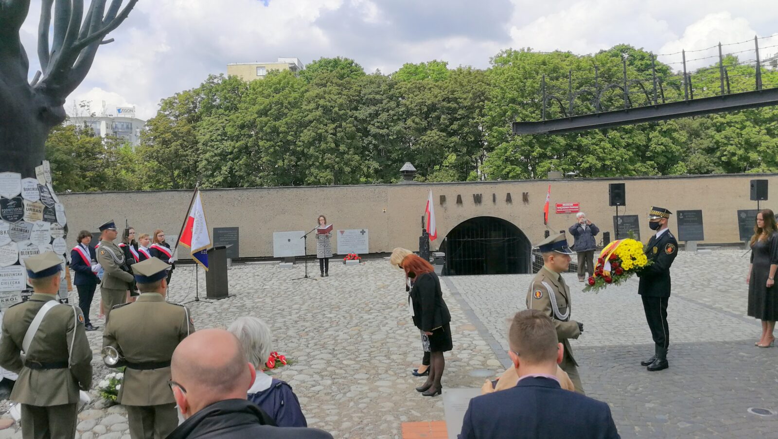 Uczestnicy uroczystości 79. rocznicy masowej egzekucji więźniów Pawiaka składają kwiaty na dziedzińcu Muzeum Więzienia Pawiak.