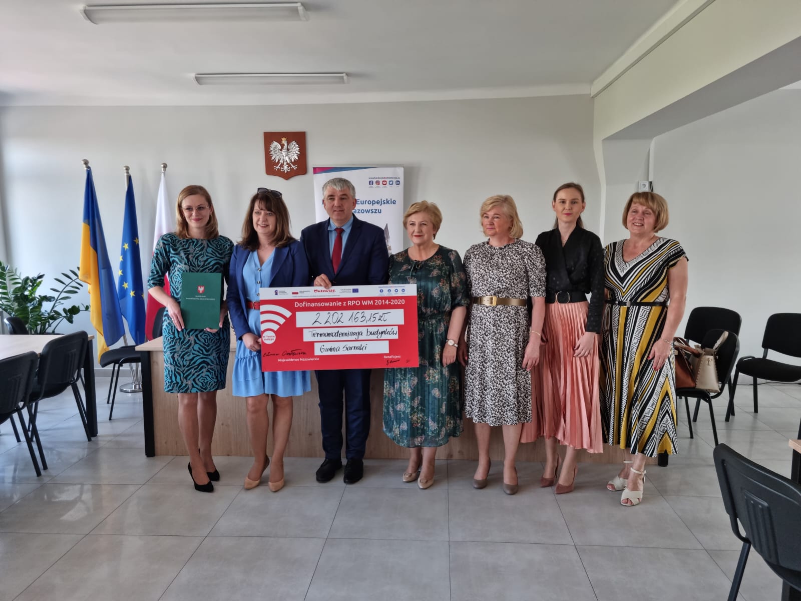 Zdjęcie z umową o dofinansowanie i pamiątkowym czekiem z udziałem przedstawicieli gminy Sarnaki i członkiń Zarządu Województwa Mazowieckiego.