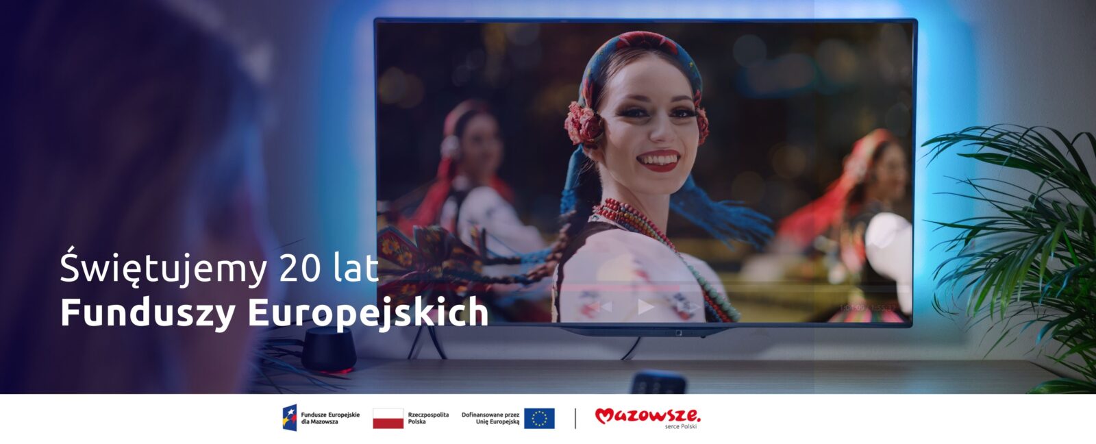 Grafika przedstawia telewizor z obrazem kobiet w tradycyjnych strojach Mazowsza. Po lewej stronie napis "Świętujemy 20 lat Funduszy Europejskich"